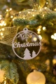 Drewniana bombka „Christmas” na choince.  Okrągła, z wyciętym napisem i świątecznymi motywami.