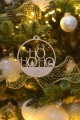 Drewniana bombka z napisem „HO HO HO”, wisząca na choince.