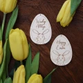 Dwie drewniane zawieszki Happy Easter w kształcie jajka z grawerunkiem z motywem zajączka.