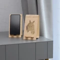 Stojak na telefon z motywem geometrycznego konia wykonany ze sklejki brzozowej, obok drugi z włożonym telefonem.