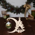 Drewniany stojak na bombkę - szopka: stojak w kształcie półksiężyca z choinką i szopką, na którym wisi bombka.