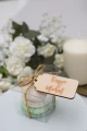 Personalizowana winietka z drewna z imionami Kuzyn & Michał na pudełku z makaronikami, ozdobiona złotą wstążką.
