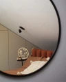 Odbicie drewnianych kwiatów na łodyżkach w okrągłym lustrze, w sypialni, sklejka brzozowa, element dekoracyjny.
