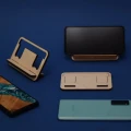 Kompaktowy stojak na telefon z drewna brzozowego, z włożonym telefonem w czarnym etui, widok z góry.
