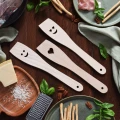 Trzy drewniane łopatki kuchenne Oczy serca: górna z oczami, środkowa z serduszkiem, dolna z uśmiechem.