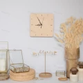 Drewniany zegar ze sklejki brzozowej na ścianie, minimalistyczny design, jasne drewno, widoczne wskazówki i godziny.